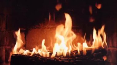 Yanan odunları olan bir şömine. Şöminede yangın var. Dinlenmek için rahat bir yer. Arka plan olarak ateş ve yakacak odun. Fırında yanan odun. Video ateşle