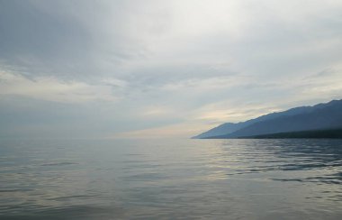 Yaz manzarası, Baykal sahilinde akşam Svyatoy Nos yarımadası yakınında, göl üzerinde gün batımı.