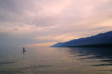 Yaz manzarası, Baykal sahilinde akşam Svyatoy Nos yarımadası yakınında, göl üzerinde gün batımı.