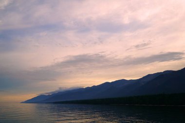 Yaz manzarası, Baykal sahilinde akşam Svyatoy Nos yarımadası yakınında, göl üzerinde gün batımı.