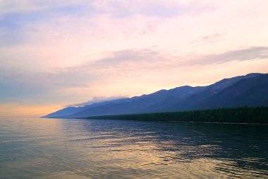 Yaz manzarası, Baykal sahilinde akşam Svyatoy Nos yarımadası yakınında, göl üzerinde gün batımı.