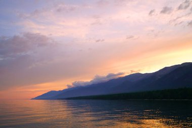 Yaz manzarası, Baykal sahilinde akşam Svyatoy Nos yarımadası yakınında, göl üzerinde gün batımı.