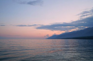 Yaz manzarası, Baykal sahilinde akşam Svyatoy Nos yarımadası yakınında, göl üzerinde gün batımı.