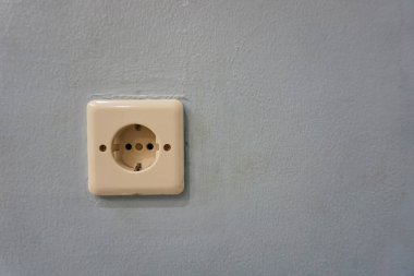 Duvardaki elektrik prizi gri