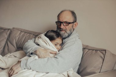 Heyecanlı, gri saçlı Ukraynalı adam korkmuş küçük torununu koruyor. Savaşı durdurun. Ukrayna için dua et. Ukrayna 'yı destekliyoruz..