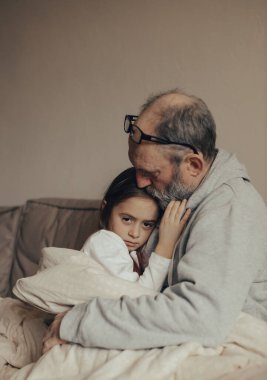 Heyecanlı, gri saçlı Ukraynalı adam korkmuş küçük torununu koruyor. Savaşı durdurun. Ukrayna için dua et. Ukrayna 'yı destekliyoruz..