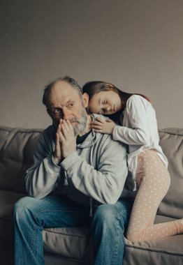 Ukraynalı endişeli orta yaşlı, ağlak adam korkmuş küçük torunu savunuyor. Torunu dedesine bakıyor. Savaşı durdurun. Ukrayna için dua et. Ukrayna 'yı destekliyoruz..