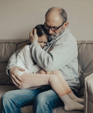 Ukraynalı heyecanlı gri saçlı adam korkmuş küçük torununu koruyor. Savaşı durdurun. Ukrayna için dua et. Ukrayna 'yı destekliyoruz..