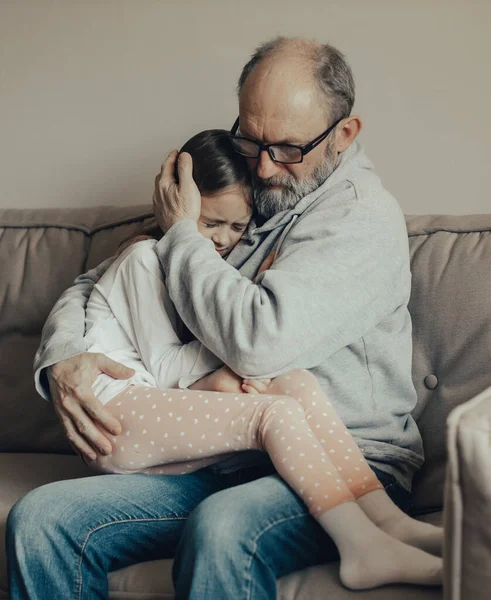 Ukraynalı heyecanlı gri saçlı adam korkmuş küçük torununu koruyor. Savaşı durdurun. Ukrayna için dua et. Ukrayna 'yı destekliyoruz..