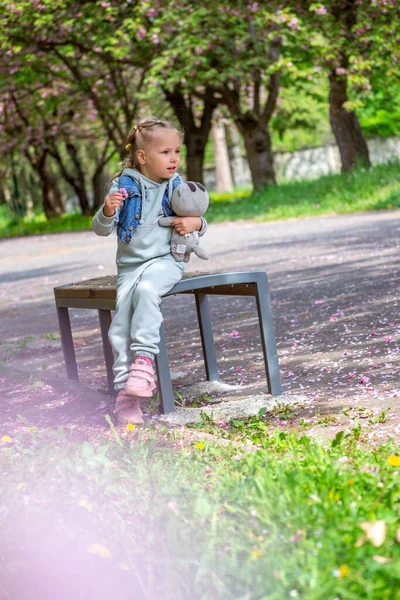 公園の裏にリュックを背負ったピンクのドレスの少女 — ストック写真