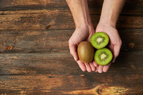 Homem Irreconhecível Mostrando Com Mãos Kiwi Inteiro Maduro Fruta Meia — Fotografia de Stock