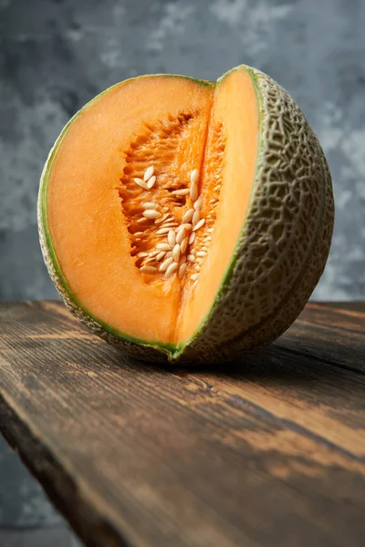 木桌上切好的甜瓜的特写 灰色背景 夏天最好的水果水果 健康食品概念 — 图库照片