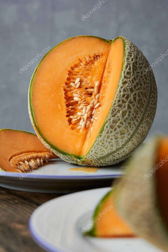 Rebanadas de melones japoneses, melón o melón sobre plato blanco y mesa