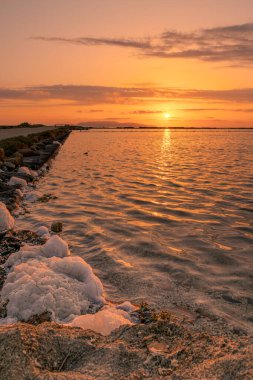 Trapani, Sicilya, İtalya 'da geleneksel tuz üretiminde günbatımı manzarası.