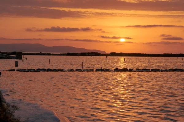 Sunset landscape of salt pans in traditional salt production in Trapani, Sicily, italy. Salt flats. Salt mines of Trapani in Italy.