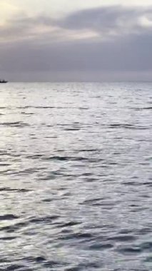 Deniz suyunun üzerinde gün batımını izleyeceğiz. Alacakaranlıkta gökyüzünde altın güneş ve deniz dalgaları kıyıya doğru koşuyor.