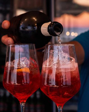 Spritz traditional cocktail with alcohol being prepared by unrecognizable man in a beach bar. European summer drink. Italian drink. Lifestyle concept