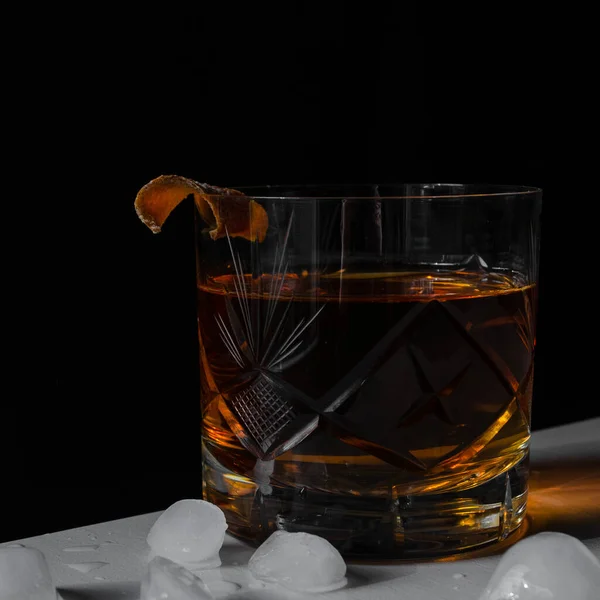 Luxury still life of whiskey glass, on the rocks, with ice. Copy space