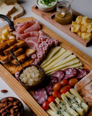Atıştırmalıkları, peyniri ve şarabı olan zarif Charcuterie Kurulu birçok insanla, aileyle, arkadaşlarıyla tatil için toplanıyor..