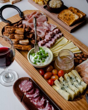 Atıştırmalıkları, peyniri ve şarabı olan zarif Charcuterie Kurulu birçok insanla, aileyle, arkadaşlarıyla tatil için toplanıyor..