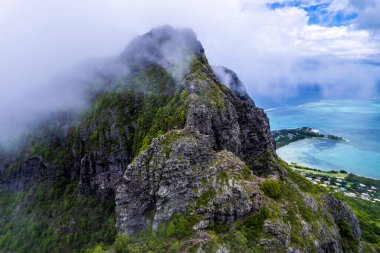 Dağların tepesindeki gökyüzü bulutlu ve yeşil ormanlı Le Morne Brabant Dağı, Mauritius. İHA 'dan ateşlenmiş..