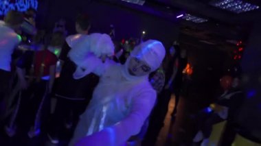 Mumya kostümlü, korkunç makyajlı bir aktörün yakın plan portresi kameraya bakar ve karanlık bir gece kulübünde eliyle vurur. Adam bandajla sarılmış. Cadılar Bayramı partisi. Tatil kavramı.