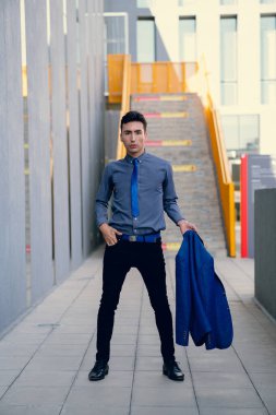 İki renkli kot pantolonlu, siyah beyaz kravatlı ve gözlüklü bir adam..