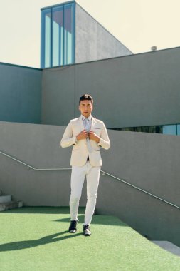 İki renkli kot pantolonlu, siyah beyaz kravatlı ve gözlüklü bir adam..