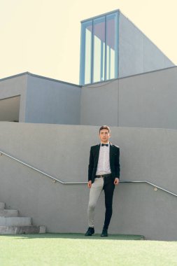 İki renkli kot pantolonlu, siyah beyaz kravatlı ve gözlüklü bir adam..