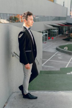 İki renkli kot pantolonlu, siyah beyaz kravatlı ve gözlüklü bir adam..