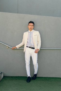 İki renkli kot pantolonlu, siyah beyaz kravatlı ve gözlüklü bir adam..