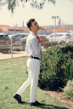 İki renkli kot pantolonlu, siyah beyaz kravatlı ve gözlüklü bir adam..