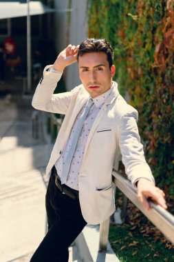 İki renkli kot pantolonlu, siyah beyaz kravatlı ve gözlüklü bir adam..