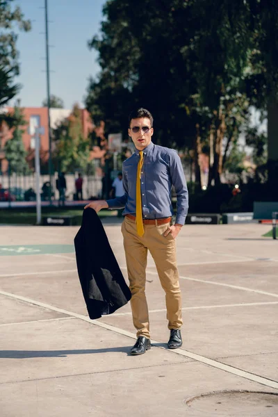 İki renkli kot pantolonlu, siyah beyaz kravatlı ve gözlüklü bir adam..