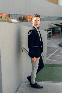 İki renkli kot pantolonlu, siyah beyaz kravatlı ve gözlüklü bir adam..