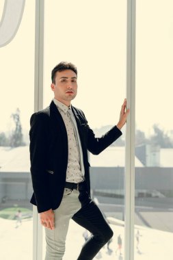 İki renkli kot pantolonlu, siyah beyaz kravatlı ve gözlüklü bir adam..