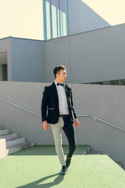 İki renkli kot pantolonlu, siyah beyaz kravatlı ve gözlüklü bir adam..