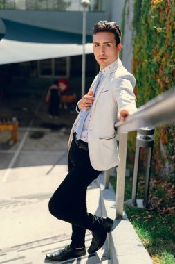 İki renkli kot pantolonlu, siyah beyaz kravatlı ve gözlüklü bir adam..