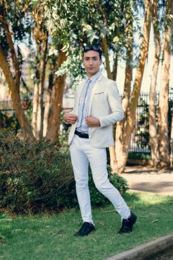 İki renkli kot pantolonlu, siyah beyaz kravatlı ve gözlüklü bir adam..