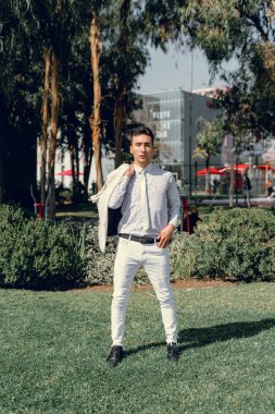 İki renkli kot pantolonlu, siyah beyaz kravatlı ve gözlüklü bir adam..