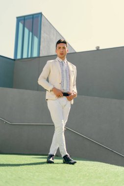 İki renkli kot pantolonlu, siyah beyaz kravatlı ve gözlüklü bir adam..