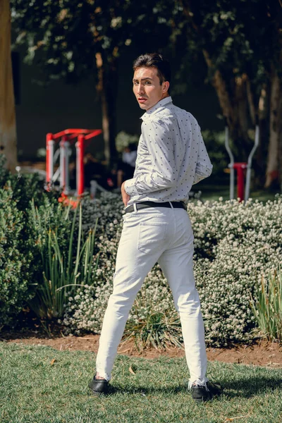 İki renkli kot pantolonlu, siyah beyaz kravatlı ve gözlüklü bir adam..