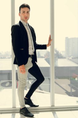 İki renkli kot pantolonlu, siyah beyaz kravatlı ve gözlüklü bir adam..