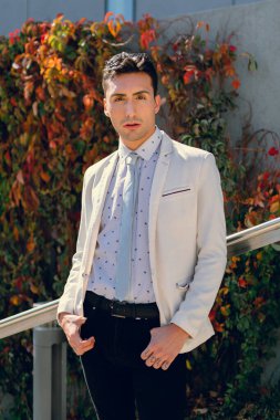 İki renkli kot pantolonlu, siyah beyaz kravatlı ve gözlüklü bir adam..