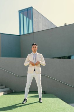 İki renkli kot pantolonlu, siyah beyaz kravatlı ve gözlüklü bir adam..