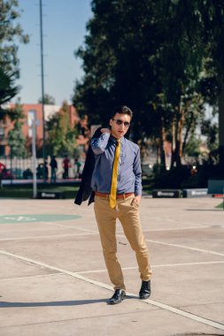 İki renkli kot pantolonlu, siyah beyaz kravatlı ve gözlüklü bir adam..