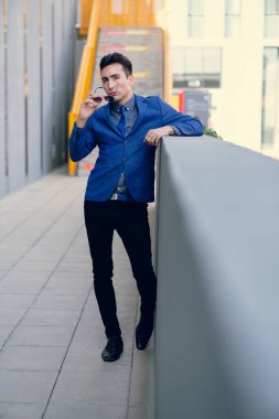 İki renkli kot pantolonlu, siyah beyaz kravatlı ve gözlüklü bir adam..