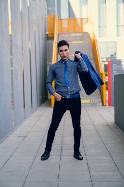 İki renkli kot pantolonlu, siyah beyaz kravatlı ve gözlüklü bir adam..