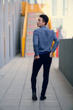 İki renkli kot pantolonlu, siyah beyaz kravatlı ve gözlüklü bir adam..