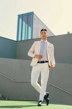 İki renkli kot pantolonlu, siyah beyaz kravatlı ve gözlüklü bir adam..